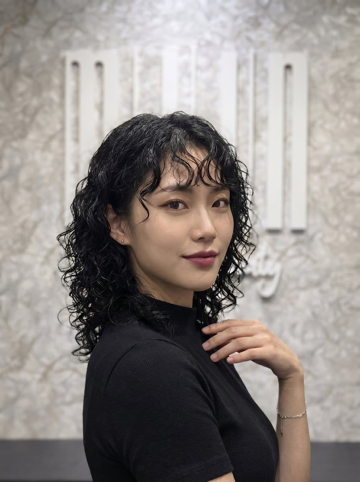 Cold perm example — tighter springier curls on shoulder-length hair